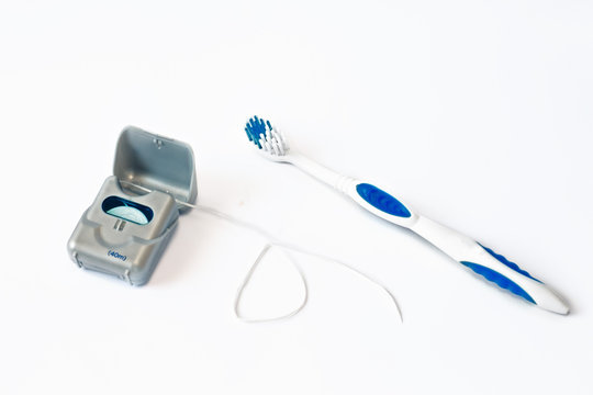 Plastic toothbrush and dental floss on white background with empty space for image or text. Toothbrush and hygienic dental thread for personal dental care. Dentistry. Toothbrush. Close-up