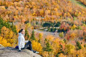 Woman hiking at Artist's Bluff in autumn. Fall colours in Franconia Notch State Park. White Mountain National Forest, New Hampshire, USA
