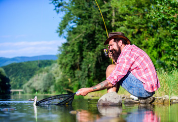 fly fish hobby. Summer activity. successful fisherman in lake water. big game fishing. relax on...