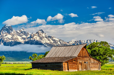 Old mormon barn in Grand Teton Mountains with low clouds. Grand Teton National Park, Wyoming, USA.