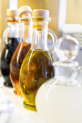 Traditional glass bottles filled with olive oil, balsamic vinegar and red wine vinegar.