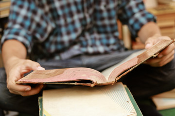 guy in a plaid shirt is studying old books