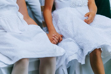 Obraz na płótnie Canvas Hande halten zwei Mädchen am Hochzeitstag Blumenmädchen