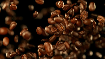 Fresh roasted coffee beans flying in the air