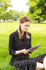 Blogger talking on line in a video conference with a laptop sitting on a bench in the street