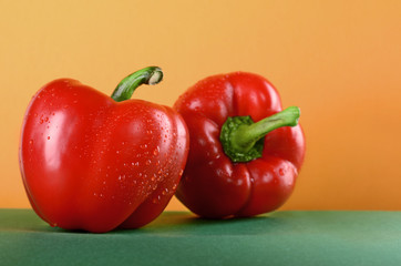 tomato and sweet pepper, paprika on the green table yellow background