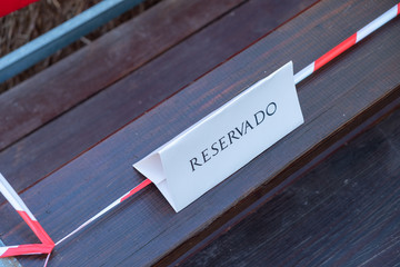 Cartel de reservado en unas grada de madera.