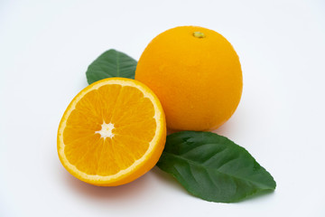 Half of orange and whole with green leaf isolated on white background