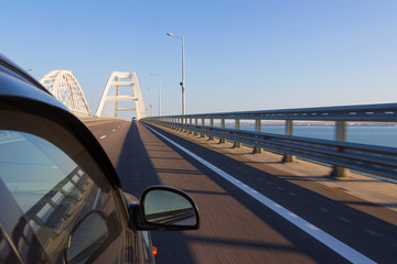 Entry to the Crimean bridge by car, view of the Crimean bridge from the window of a moving car in the summer morning