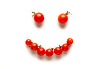 Red and yellow cherry tomatoes, fresh bright organic vegetables. Smiling face.