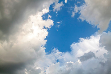 Cumulus clouds gather before the rain against a clear blue sky. Natural landscape.