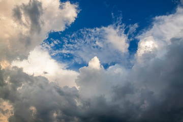 Fototapeta na wymiar Cumulus clouds gather before the rain against a clear blue sky. Natural landscape.