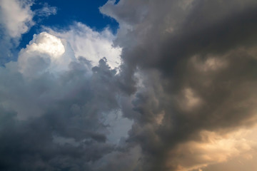 Cumulus clouds gather before the rain against a clear blue sky. Natural landscape.