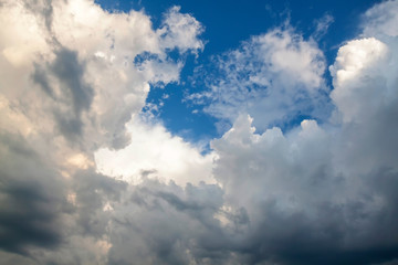 Cumulus clouds gather before the rain against a clear blue sky. Natural landscape.