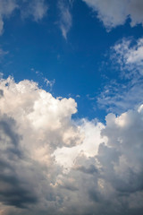 Cumulus clouds gather before the rain against a clear blue sky. Natural landscape.