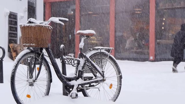 City Bicycle With A Shopping Cart Standing On The Street During Snowfall