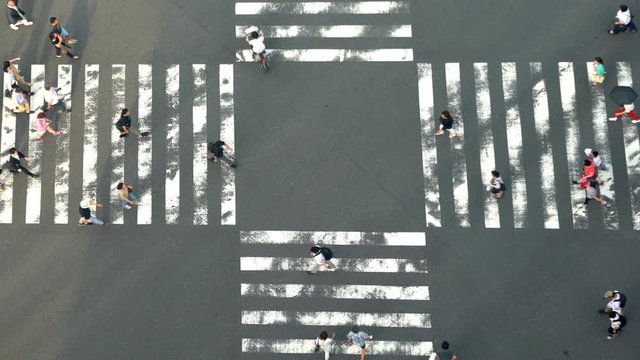 July 28, 2019 : Ginza, Tokyo, Japan 4K High Angle view wide shot of pedestrian people crowd man and woman walking cross intersection street crosswalk with shadow on the road in afternoon summer day.