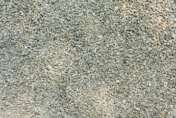 A lot of small pebbles lies on a path in the park. Preparing the road for leveling. Stone background