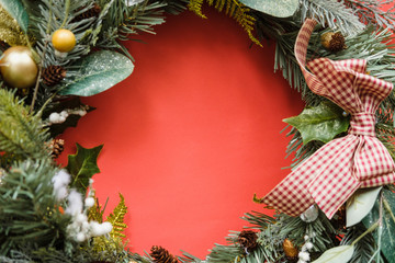 Christmas wreath with pine branches and berries like frame on red background. Christmas, New Year, Winter Holidays concept, sale. Copy Space