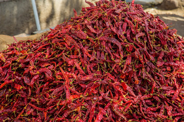 Naklejka premium Heap of dried red chilly kept outside a shop in a spice market. background - image
