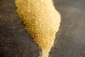 Golden shining sand on black background. Christmas card template