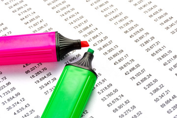 Red and geen marker on a white sheet of paper with printed financial numerical data table money numbers. Concept for accounting, budget, profit, tax and financial review.  