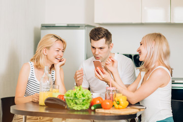 Friends sitting at table in kitchen