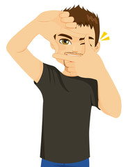 Young happy man making photo framing hands gesture
