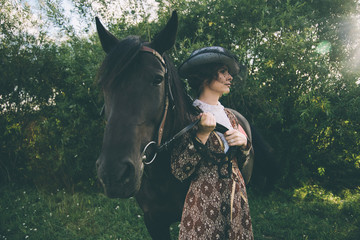 Militant independent girl in a beautiful dress of delicate brown, riding on a brown horse