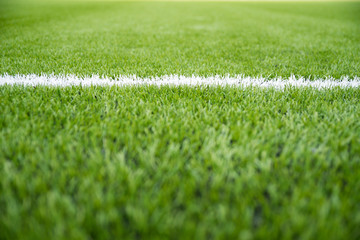 Texture of artificial grass herb cover sports field. It is used in different sports: football, tennis, baseball, soccer, american football, cricket, golf, field hockey, rugby.