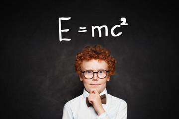 Little genius portrait. Young child boy student on chalkboard with science formula