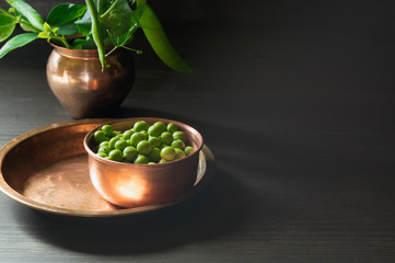 Young green peas on white wooden background.