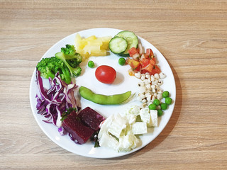 Smiling face salad dish on wooden table