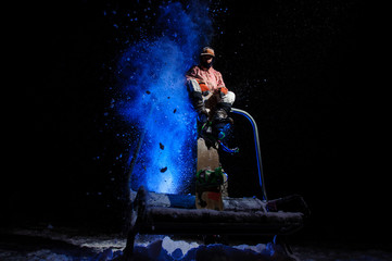 Active male snowboarder dressed in a white and pink sportswear sitting on the funicular seat
