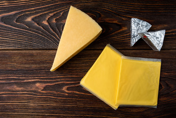 Processed cheese on dark wooden background.