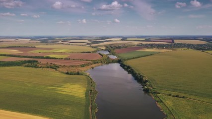 Aerial hyperlapse of rural fields and green landscapes during sunny day