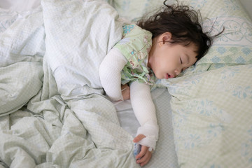 Asian little girl lying in bed at hospital, Baby girl sick from skin allergies, She was wrapped with a bandage on the neck and both arms, Atopic dermatitis (AD)