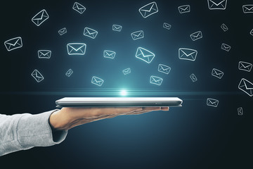Hand holding tablet with emails