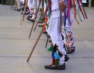 Professional dancers of the Timisul Folklore Ensemble hold hands in a traditional Romanian dance wearing traditional beautiful costumes.