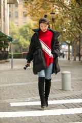 Stylish Asian girl wearing long black down jacket on the street
