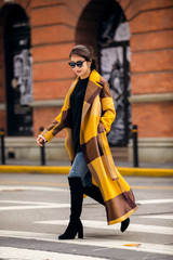 Asian fashion girl in yellow trench coat with black sunglasses on the street © jeson