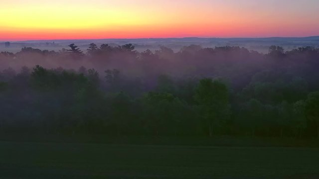 Warm country landscape steaming in the cold air of twilight, late Summer, aerial view.