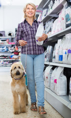 woman buying pet food for Afghan Shepherd puppy in shop for animal