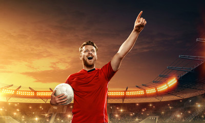 Fototapeta na wymiar Soccer player with ball on a stadium celebrates championship. Victory, triumph.