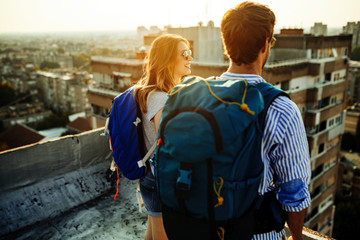 Multiethnic traveler couple using map together on sunny day