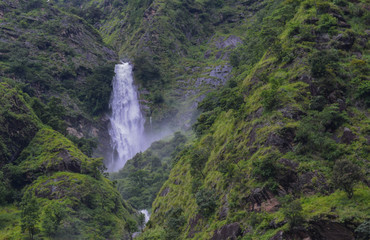 white waterfall on green hill