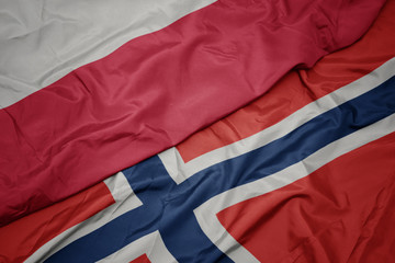waving colorful flag of norway and national flag of poland.