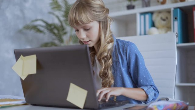 cute 10 years old girl is playing a computer game intently 4K