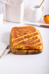 Homemade citrus sponge cake. Orange biscuit on white table.