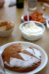 Homemade sponge cake served on a table with whipped cream and cooked peaches and apricots. Selective focus.